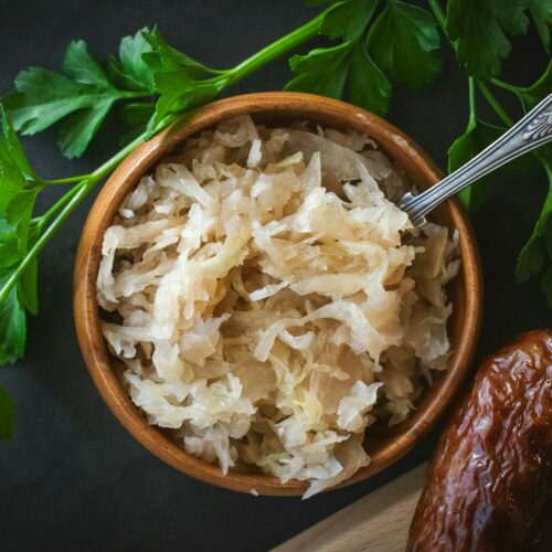 a wooden bowl filled with rice next to a spoon